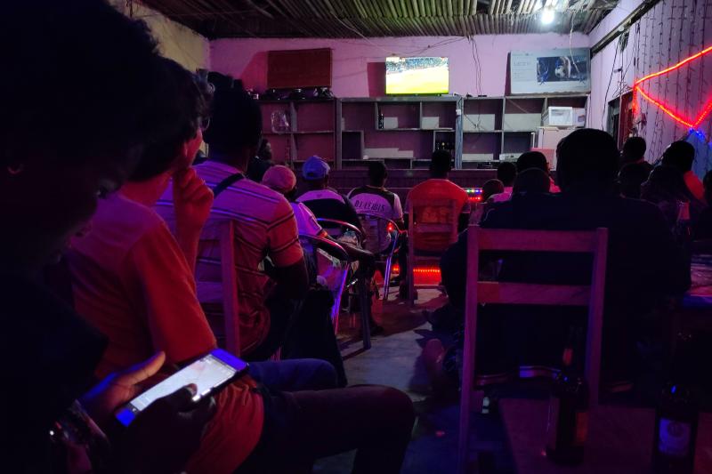 Gruppe von Menschen Fußball-schauend in einer Bar mit Bier auf den Tischen.